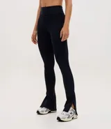Pantalón deportivo tipo legging flare de tiro alto, confeccionado en microfibra con abertura lateral en el ruedo.