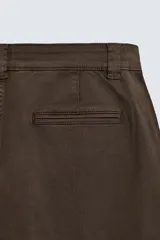 Pantalón cargo de corte relajado confeccionado en tejido de algodón con elasticidad. Presenta bolsillos laterales tipo cargo con solapa en las perneras, bolsillos frontales y bolsillos traseros de doble vivo. Cierre frontal con cremallera y botón.