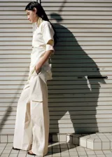 Pantalón recto color blanco crudo, de tiro medio con bolsillos laterales y bolsillos cargo con solapa en las piernas.