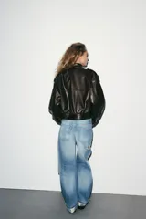 Jeans de tiro medio con corte baggy, cinco bolsillos y bajo con dobladillo. Cierre frontal con cremallera y botón metálico.
