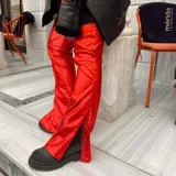 Pantalón de ecocuero rojo brillante, de corte recto y con tachas plateadas en el lateral.