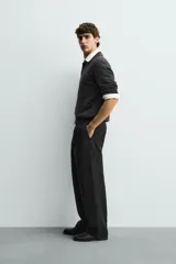 Pantalón de corte wide fit confeccionado en tejido con mezcla de lyocell. Presenta pliegues frontales dobles, bolsillos laterales y bolsillos traseros de vivo. Cierre frontal con cremallera y gancho metálico oculto.