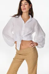 Camisa de lino italiano con estampado a rayas verticales irregulares, de corte holgado, cuello clásico, mangas abullonadas y cierre frontal con botones.