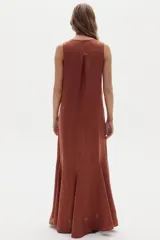 Vestido largo de lino marrón, sin mangas, con cuello a la base y canesú en la espalda. Cuenta con godets en el ruedo que le aportan movimiento y amplitud.