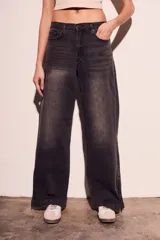 Pantalón de jean negro con efecto desgastado, corte wide leg y cierre con cremallera en los tobillos.