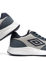Championes Umbro modelo Volcan para hombre, en tonos de azul y gris claro, con cordones azules y suela blanca. Presentan el logo de Umbro en el lateral.