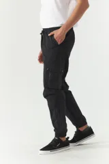 Pantalón cargo gris de nylon con cintura ajustable, bolsillos laterales con solapa y puños elásticos.