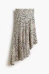 Pollera midi asimétrica de viscosa, con estampado animal print de leopardo, tiro alto y elástico oculto en la cintura. Presenta costura diagonal en las caderas y caída al bies con bajo irregular.