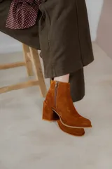 Botinetas de cuero color marrón, con diseño de caña baja, taco cuadrado y cierre lateral.
