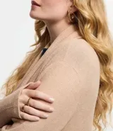 Cardigan alargado de punto color gris, con abertura frontal y bolsillos laterales.