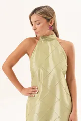 Vestido largo verde con cuello halter, cuerpo con diseño de rombos pespuntados y falda fluida transparente.