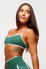 Top deportivo verde con detalles en blanco, logo minimalista y tirantes ajustables. Fabricado en poliamida y elastano con protección UV50+.