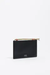 Neceser de cuero negro con cierre de cremallera y tirador de cordón bicolor. Presenta el logo de la marca en metal plateado en la parte frontal.