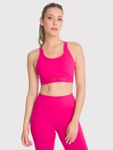 Top deportivo de soporte medio color fucsia, con espalda estilo nadador que presenta detalles de encaje en los tirantes. Incluye sujetador integrado y almohadillas removibles.