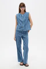 Pantalón de jean de corte recto y tiro bajo con diseño de rayas verticales en tonos azules y sutiles líneas rojas.