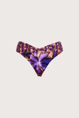 Bombacha de bikini con diseño tipo corset, caracterizada por una faja ancha cruzada en la cintura. Presenta un estampado botánico con hojas en tonos púrpuras y cobrizos, con un corte en V que estiliza la figura.