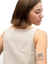 Musculosa de lino con cuello redondo, diseño holgado y laterales abiertos unidos por tres tiras horizontales.