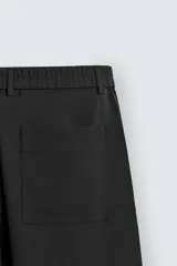 Pantalón de corte relaxed fit, con cintura ajustable, bolsillos delanteros y bolsillo trasero de plastrón. Presenta cierre frontal con cremallera y botón.