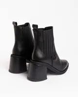 Botas tipo chelsea de cuero vacuno negro, con elásticos laterales, taco cuadrado y punta fina.