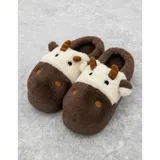 Pantuflas de peluche con diseño de vaca, confeccionadas en piel sintética suave. Cuentan con suela de goma antideslizante y diseño abierto en el talón.