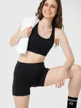 Conjunto deportivo compuesto por un top de escote redondo y espalda deportiva, y un short de tiro alto ajustado. Ambas piezas son de color negro y diseño liso.