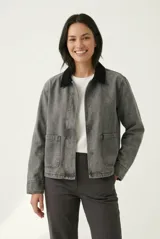 Campera de denim gris con efecto deslavado, cuello camisero de terciopelo negro, bolsillos frontales aplicados y cierre con botones metálicos.
