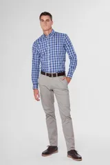 Pantalón de gabardina color marrón claro, corte slim fit, con bolsillos laterales y traseros. Se ajusta a la cintura con cinturón de cuero marrón.