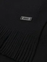 Bufanda de punto Raschel color blanco hueso, con diseño liso y terminación en flecos cortos. Incluye una pequeña etiqueta metálica con el logo de la marca.