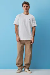 Remera blanca de algodón, de corte holgado y mangas cortas, con pequeño estampado azul en el pecho.