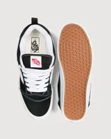 Championes Vans modelo Knu Skool, de diseño inspirado en los años 90 con silueta voluminosa. Confeccionados en gamuza negra, presentan lengüeta y cuello acolchados, Sidestripe en relieve 3D, tiradores en el talón y suela de goma con diseño waffle.