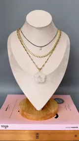 Collar con cadena de eslabones tipo bolita dorada y dije de piedra natural tallada en forma de flor con una pequeña circonia incrustada en el centro.