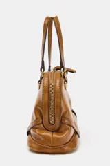 Bolso mini bandolera de cuero sintético en color tostado, con doble asa corta de mano, herrajes metálicos dorados y cierre superior con cremallera.