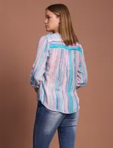 Blusa de gasa con estampado de rayas verticales en tonos celestes, violetas y blancos. Presenta cuello mao con escote en V, cierre frontal con botones, bolsillo aplicado en el pecho y mangas largas con presilla para regular el largo. El diseño incluye un nudo en la parte inferior delantera.
