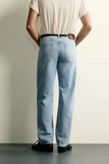 Jeans de corte recto en tono azul clásico con efecto lavado, tiro medio y diseño de cinco bolsillos con cierre frontal de botones.