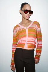 Pantalón de vestir color rosado, tiro bajo, con corte acampanado (flare) y costuras laterales marcadas. Cierre frontal con botón interior y gancho.