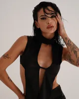 Top negro satinado con cuello alto, sin mangas y abertura central en el pecho.