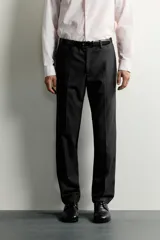 Pantalón de traje slim fit para hombre, color gris oscuro, con bolsillos frontales y bolsillos traseros de doble vivo con botón. Cuenta con cierre frontal de cremallera y botón, y presillas para cinturón.
