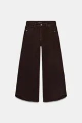 Jeans de tiro alto con diseño balloon, pernera ancha y corta, y bajo asimétrico. Cuenta con cinco bolsillos y cierre frontal con cremallera y botón.