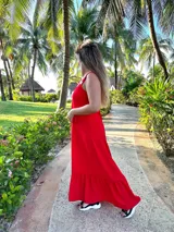 Vestido largo fucsia con breteles finos y detalle de tachas doradas en los breteles.