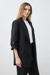 Blazer de corte recto y diseño minimalista, color blanco, con solapas clásicas, bolsillos frontales con solapa y mangas tres cuartos con detalle de botones.