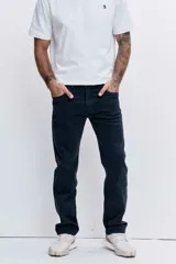 Pantalón de jean corte regular, color azul oscuro, con cierre de botón y cremallera, y bolsillos laterales y traseros.