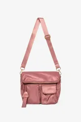 Cartera tipo bandolera de tela satinada color rosado, con correa ajustable, cierre principal superior y dos bolsillos frontales con cierre.