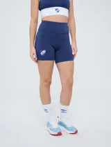 Calza corta tipo biker azul marino, de tiro alto, con el escudo del Club Nacional de Football estampado en la pierna derecha.