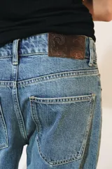 Jeans de tiro bajo y diseño wide leg de la colección ZW Collection de Zara, con efecto lavado, cinco bolsillos, trabillas en la cintura y cierre frontal con cremallera y botón metálico.
