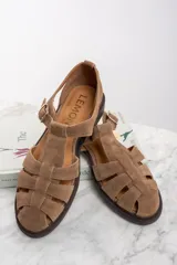 Sandalias cangrejeras de gamuza color marrón con hebilla dorada.