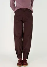 Pantalon de gabardina en color azul oscuro, de corte holgado con botamangas ajustadas mediante elástico.