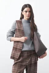 Chaleco de sastrería con estampado de cuadros en tonos tierra, diseño estructurado con escote en V y cierre frontal con botones.