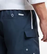 Bermuda de baño azul marino con cintura elástica, cordón de ajuste, bolsillos cargo y detalles de rayas laterales blancas.