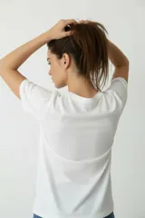 Remera de algodón manga corta con cuello redondo y corte al cuerpo. Presenta un estampado central con diseño artístico y detalles de studs aplicados.