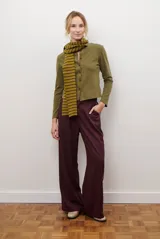 Pantalón de corte recto y pierna ancha, color bordó, con tiro alto y cintura elástica. Cuenta con bolsillos laterales y cierre frontal.